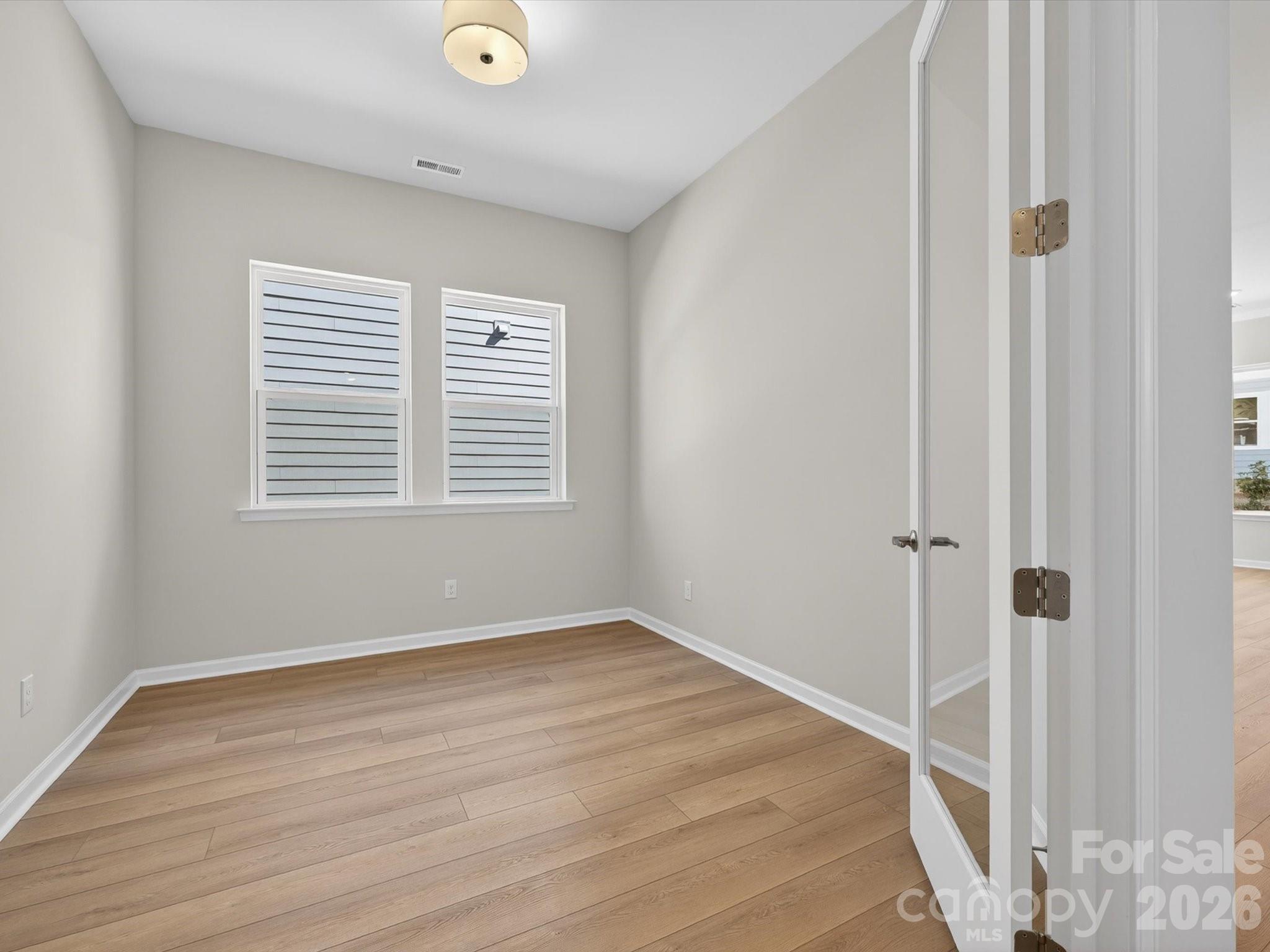 1007 Meander Lane Waxhaw, NC 28173 - Photo 5 of 35 a view of an empty room with wooden floor and a window