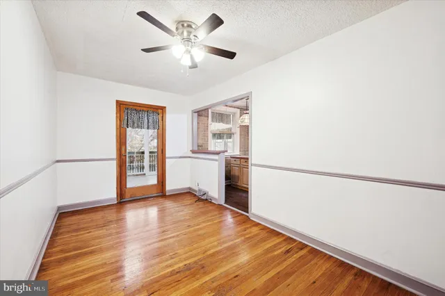 a view of a big room with wooden floor and a kitchen