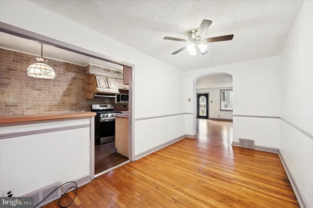 a hallway with wooden floor a chandelier and entryway
