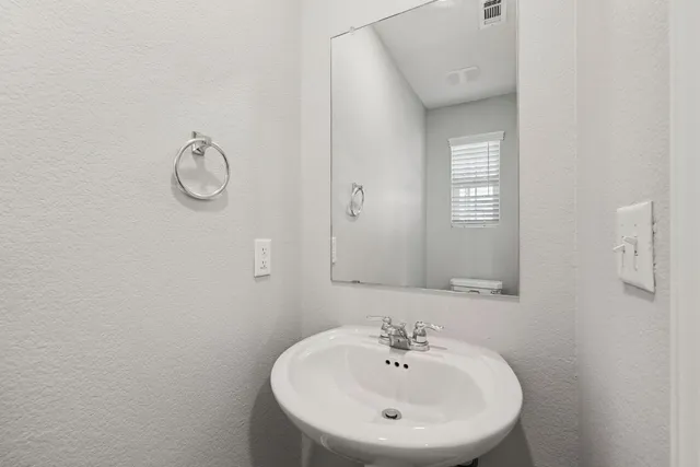 a bathroom with a sink a mirror and a window