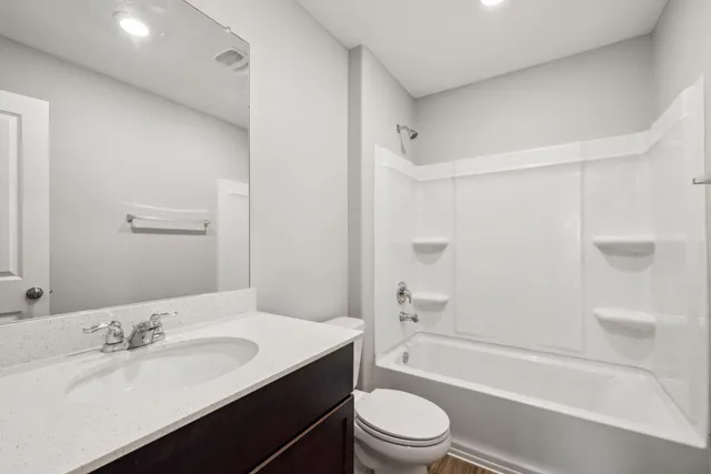 a bathroom with a granite countertop sink toilet tub and shower