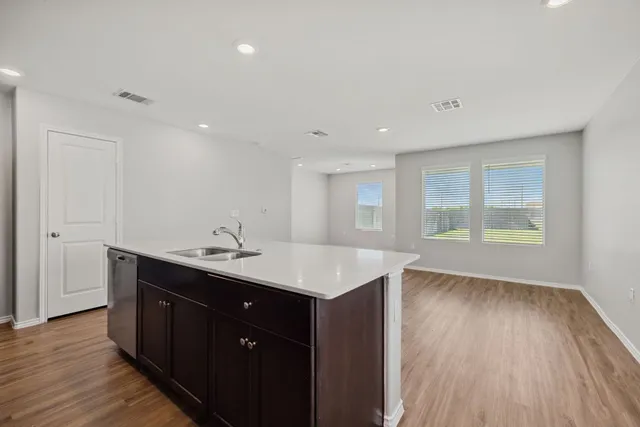 a kitchen with a sink and wooden floor