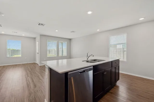 a kitchen with a sink a window and wooden floor