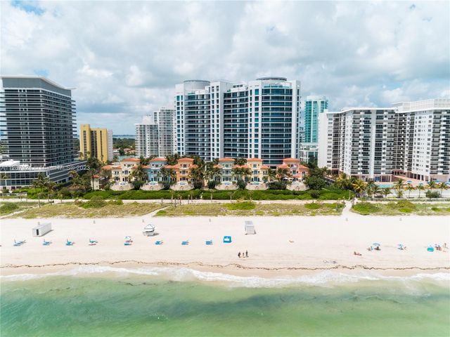 a front view of a house with a garden and trees