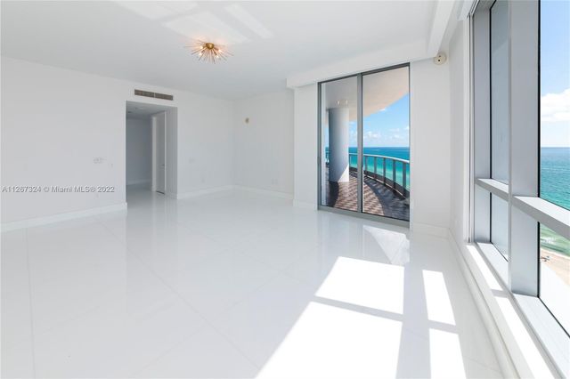 an empty room with sliding glass door and shower