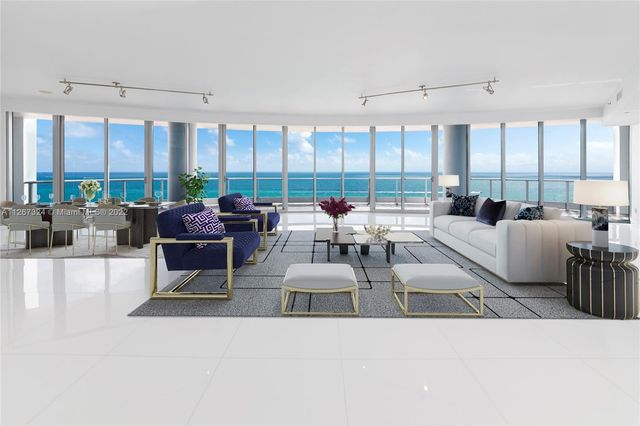 a living room with furniture and large windows