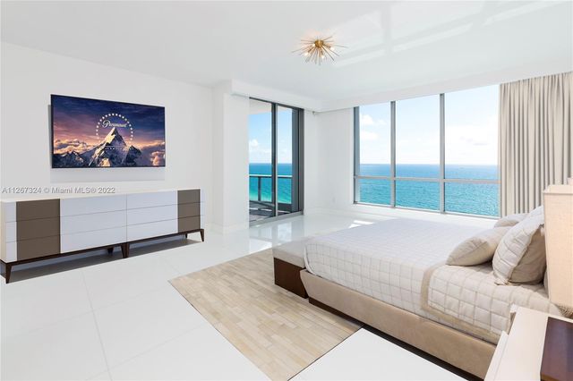 a living room with a bed and a large window