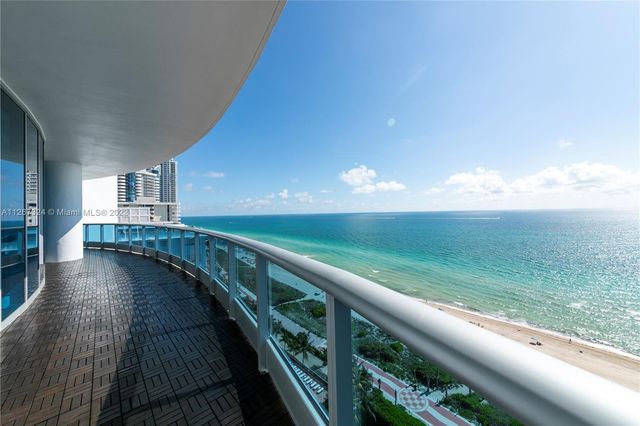 a large white kitchen with a sink and a large mirror