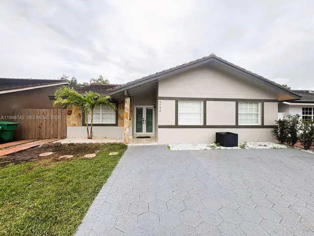 a kitchen with stainless steel appliances granite countertop a refrigerator a stove a microwave a sink and white cabinets