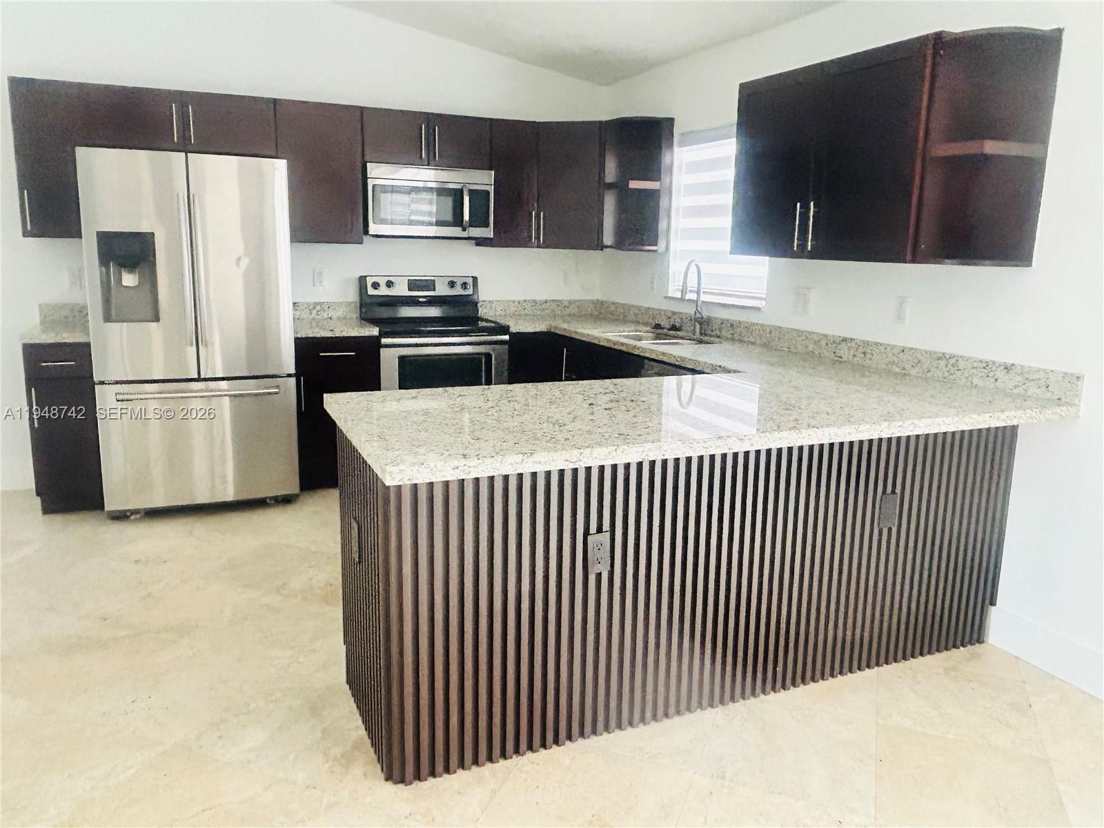9752 Southwest 145th Place, Unit 9752 Miami, FL 33186 - Photo 2 of 17 a kitchen with stainless steel appliances granite countertop a refrigerator a stove a microwave a sink and white cabinets