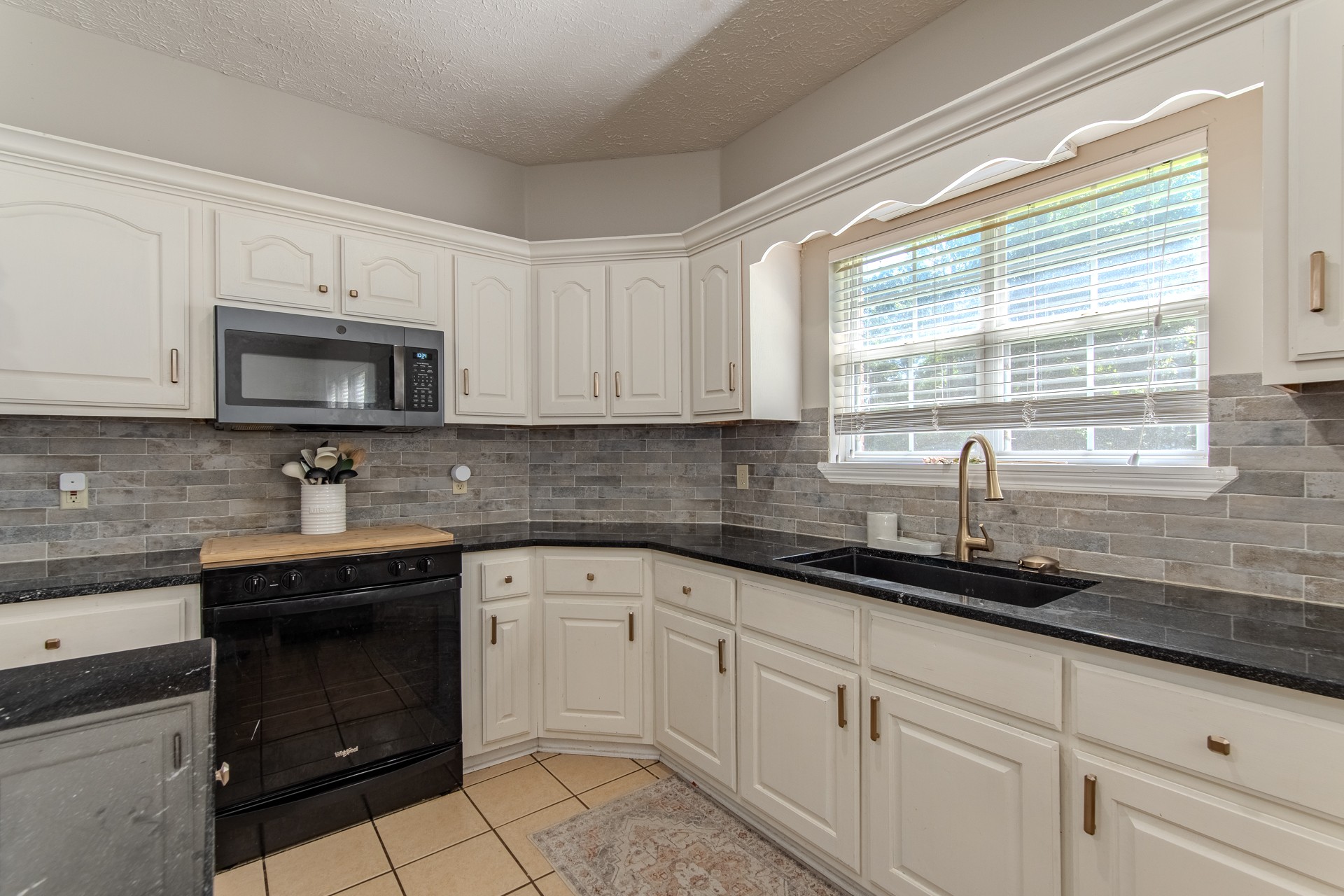 915 Cliffview Road Bolivar, TN 38008 - Photo 70 of 89 a kitchen with granite countertop white cabinets sink and stainless steel appliances