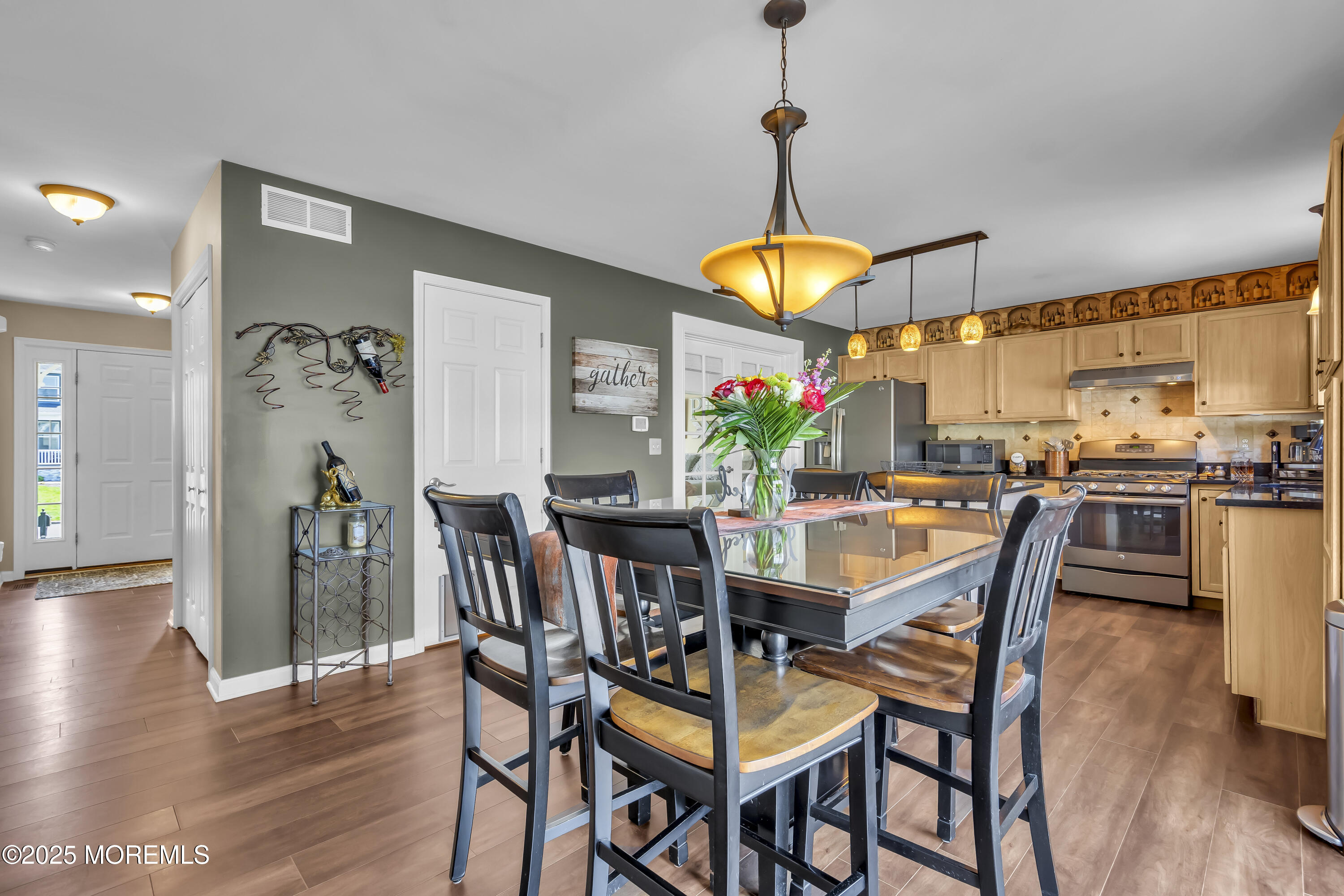 1839 Breakers Drive Manahawkin, NJ 08050 - Photo 19 of 52 a dining room with wooden floor a chandelier a wooden table and chairs