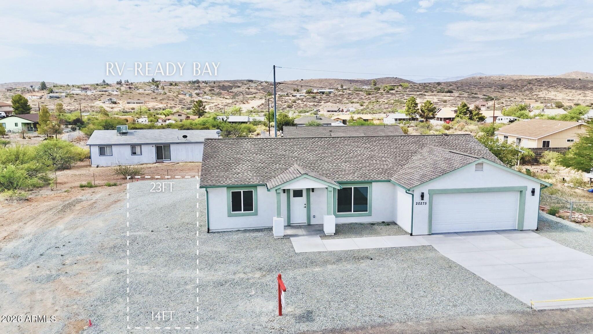 a front view of a house with a yard and mountain view in back