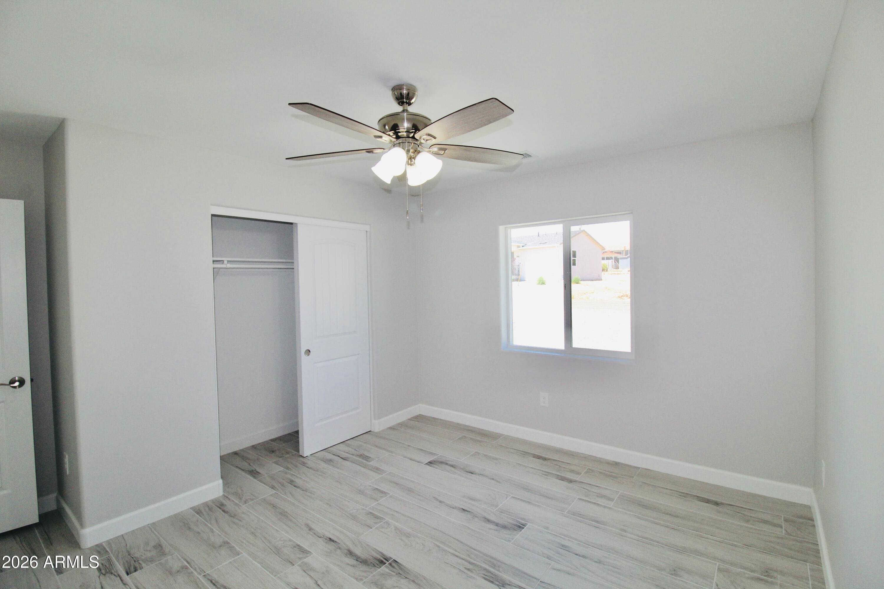 20275 East Mesa Verde Road, Unit 503 Mayer, AZ 86333 - Photo 15 of 32 an empty room with wooden floor fan and windows