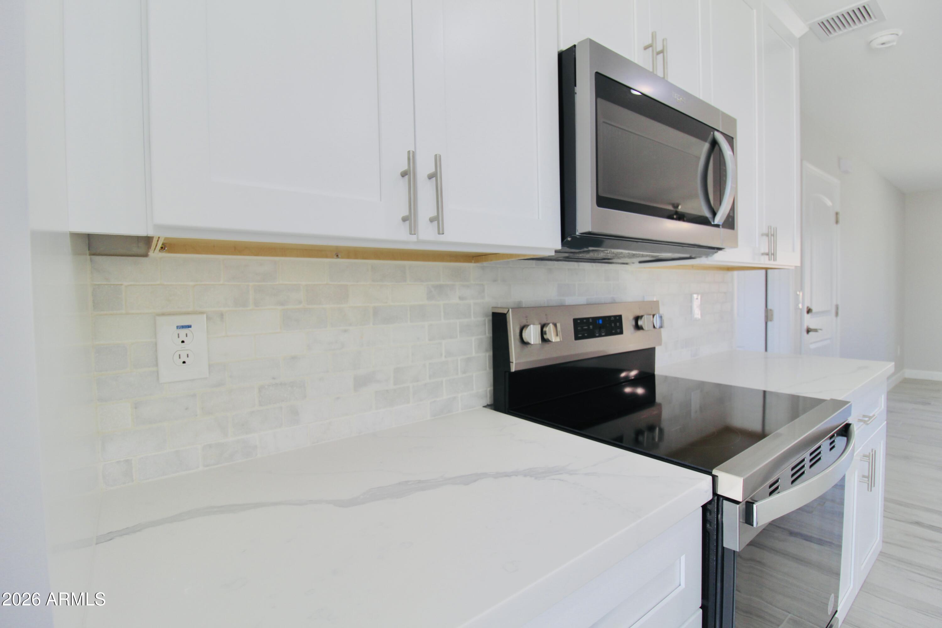 20275 East Mesa Verde Road, Unit 503 Mayer, AZ 86333 - Photo 17 of 32 a kitchen with stainless steel appliances a sink a stove and microwave