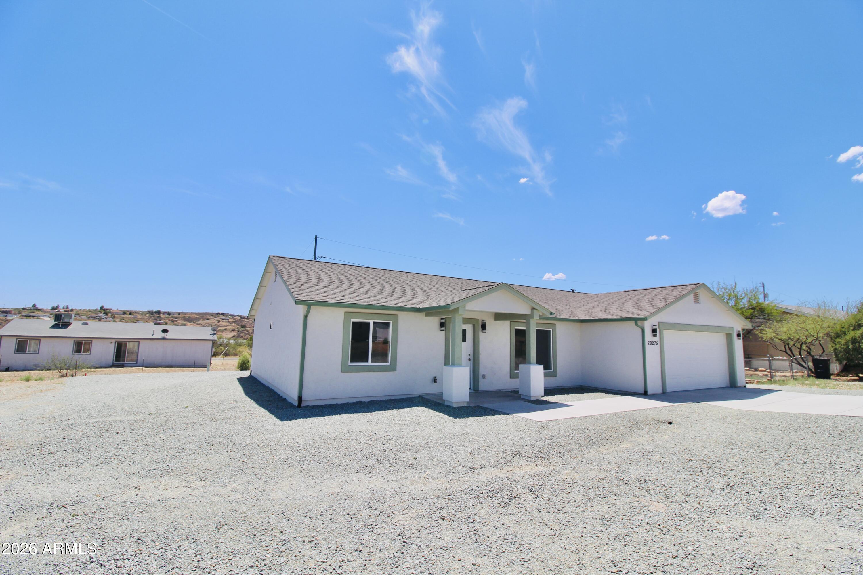 20275 East Mesa Verde Road, Unit 503 Mayer, AZ 86333 - Photo 2 of 32 a front view of a house with a yard and garage