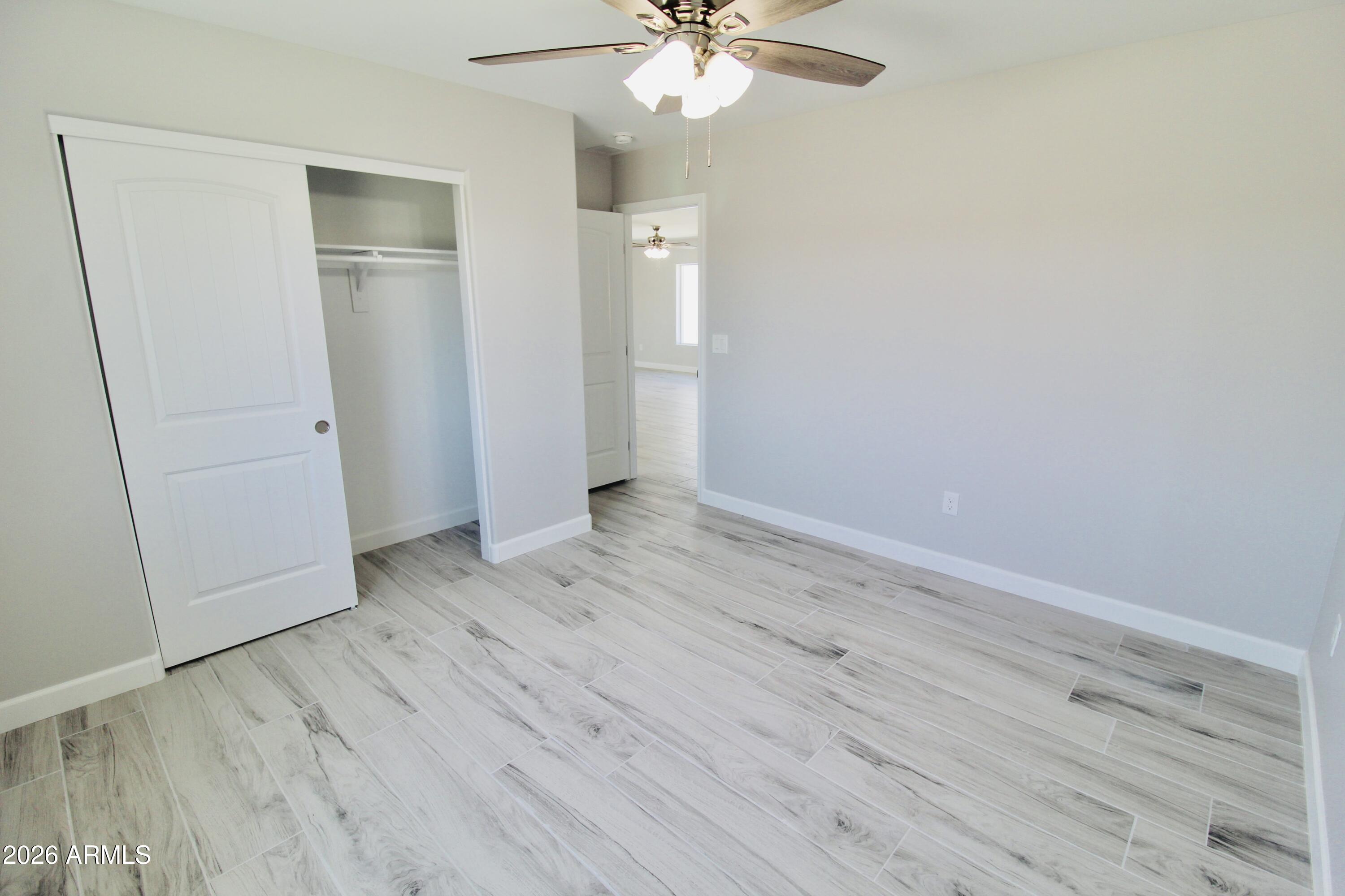 20275 East Mesa Verde Road, Unit 503 Mayer, AZ 86333 - Photo 9 of 32 an empty room with wooden floor and closet