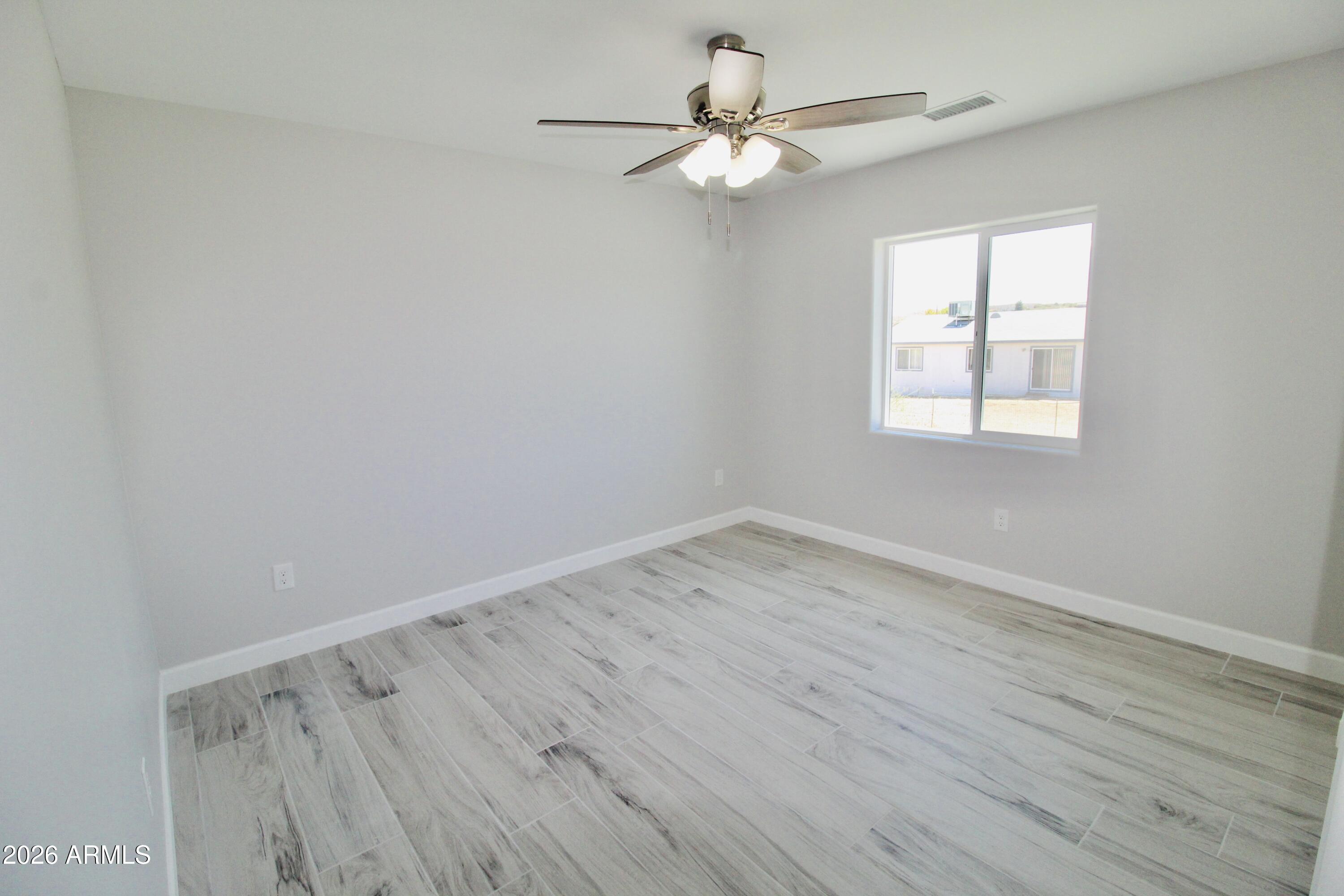 20275 East Mesa Verde Road, Unit 503 Mayer, AZ 86333 - Photo 10 of 32 wooden floor in an empty room with a window