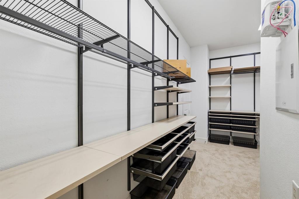 1933 Snapdragon Road Frisco, TX 75033 - Photo 23 of 40 Custom closet system featuring multiple shelving options, wire racks, integrated drawers, and carpeted flooring
