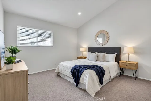 a backyard of a house with fountain plants and large tree