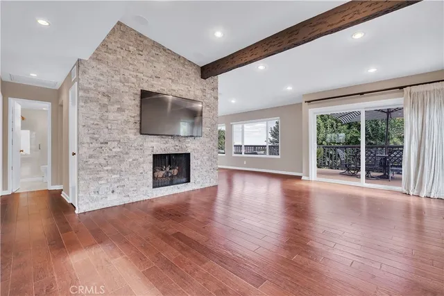 a kitchen with stainless steel appliances granite countertop a stove a sink a microwave a dining table and chairs with wooden floor