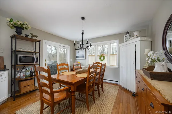 a dining room with furniture a chandelier and wooden floor