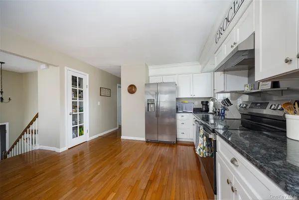 a kitchen with granite countertop a refrigerator stove top oven and sink