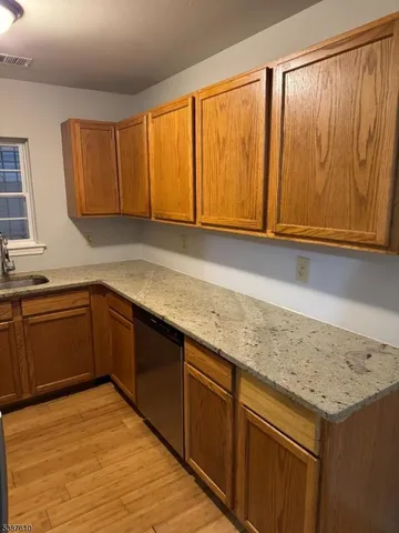 a kitchen with a sink a microwave cabinets and a window