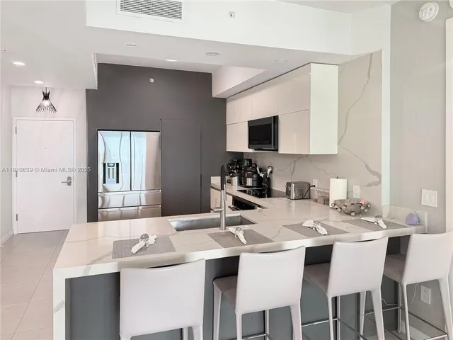 a kitchen with a sink and chairs