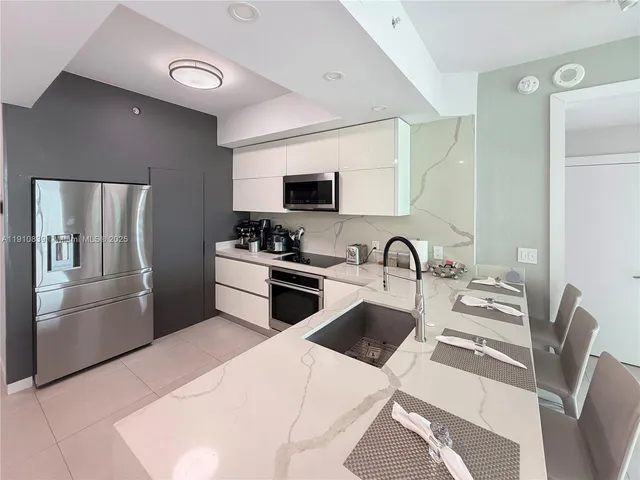 a kitchen with stainless steel appliances kitchen island a refrigerator sink and stove