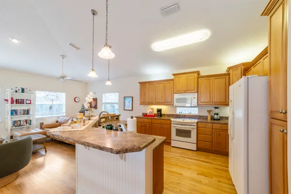 a kitchen with stainless steel appliances granite countertop a sink a stove and refrigerator