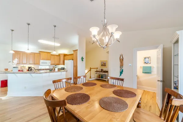 a view of a dining room with furniture a chandelier and wooden floor