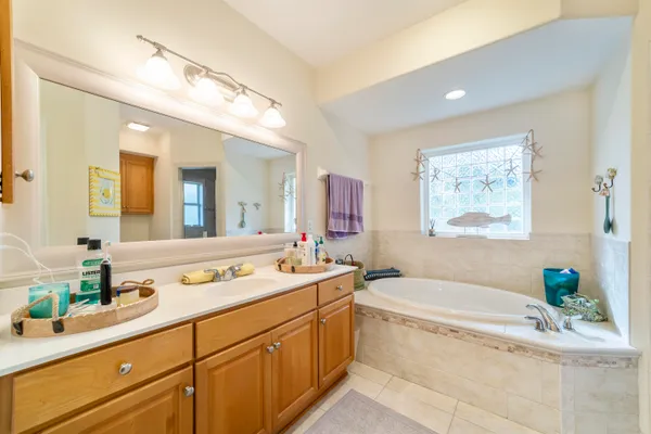 a spacious bathroom with a granite countertop tub sink and mirror