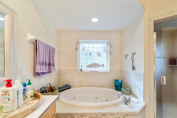 a bathroom with a tub sink and mirror