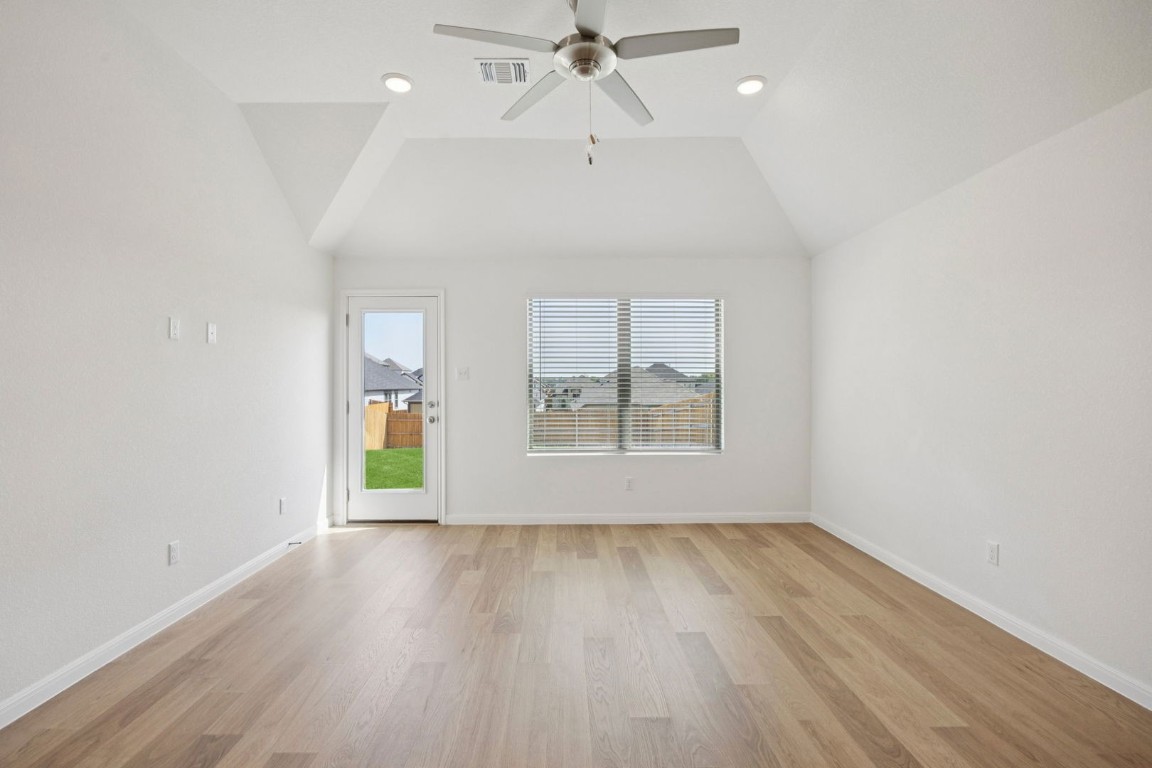 332 Bendecido Loop Elgin, TX 78621 - Photo 14 of 33 an empty room with wooden floor a ceiling fan and windows