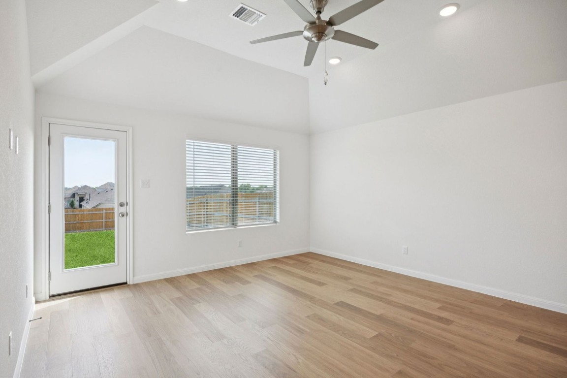 332 Bendecido Loop Elgin, TX 78621 - Photo 16 of 33 an empty room with wooden floor fan and windows
