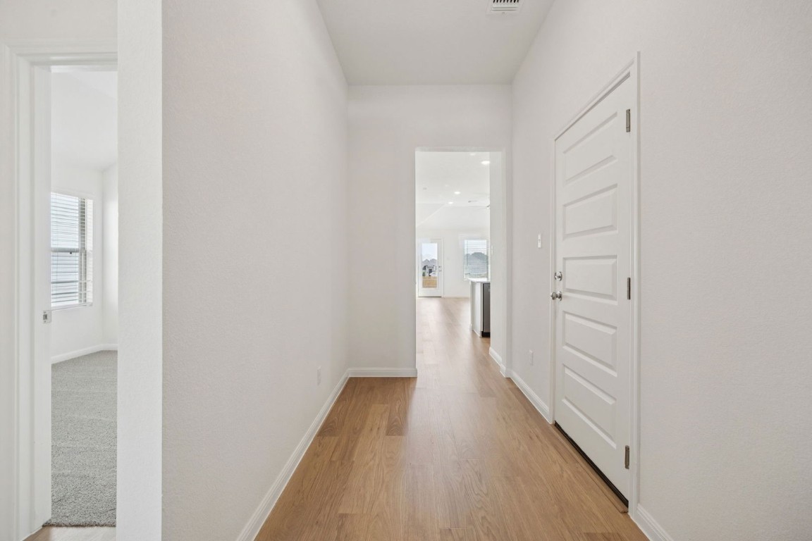332 Bendecido Loop Elgin, TX 78621 - Photo 27 of 33 a view of a hallway with wooden floor