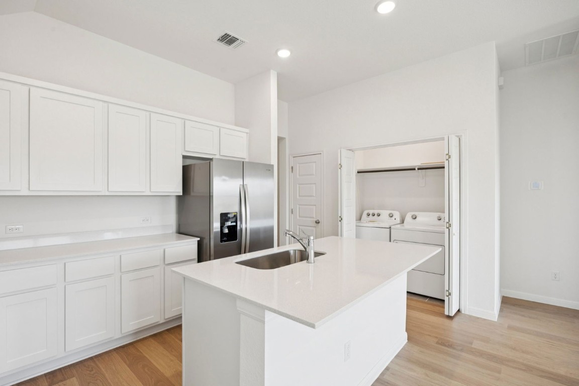 332 Bendecido Loop Elgin, TX 78621 - Photo 5 of 33 a kitchen with a refrigerator a sink and cabinets