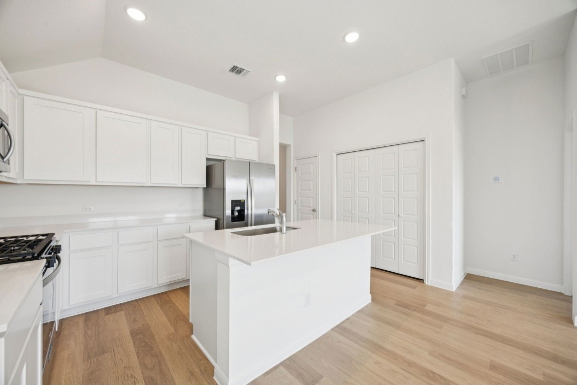332 Bendecido Loop Elgin, TX 78621 - Photo 7 of 33 a kitchen with stainless steel appliances a sink a stove a refrigerator and cabinets