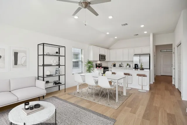 a view of kitchen with stainless steel appliances living room dining table and chairs