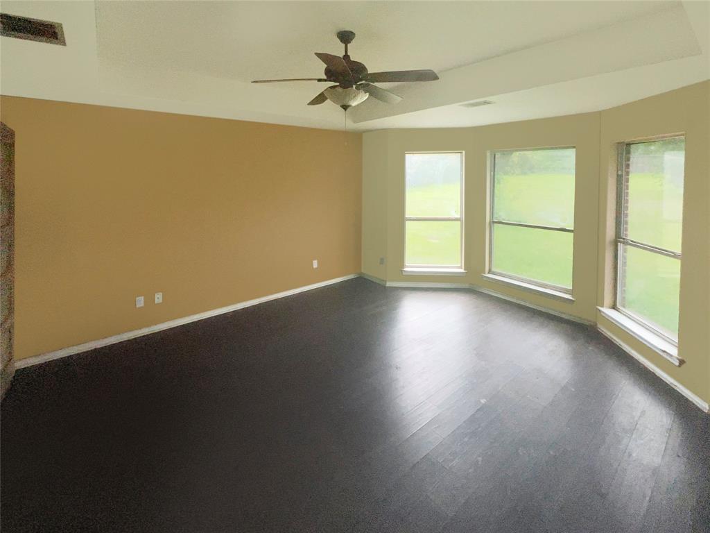 3661 Emo Street Midlothian, TX 76065 - Photo 11 of 24 an empty room with wooden floor fan and windows