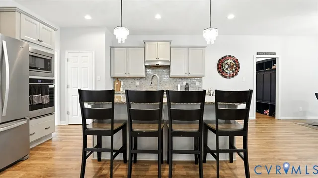 a utility room with stainless steel appliances lots of clutter