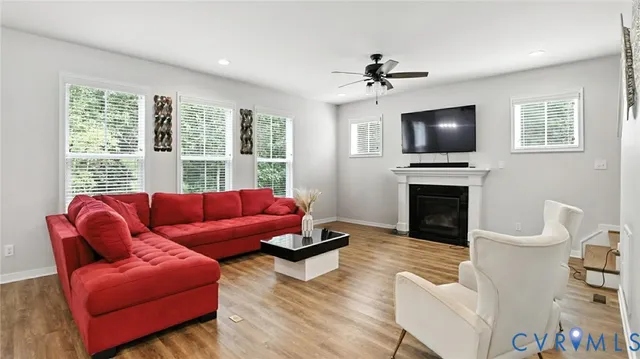 a living room with furniture a wooden floor and a fireplace