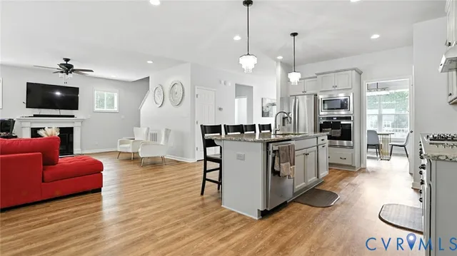 a large kitchen with granite countertop a large island in the center and stainless steel appliances