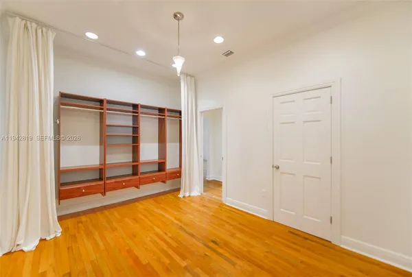 a view of empty room with wooden floor