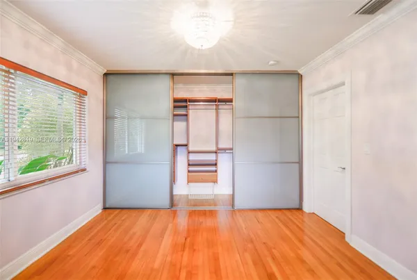a view of empty room with window and wooden floor