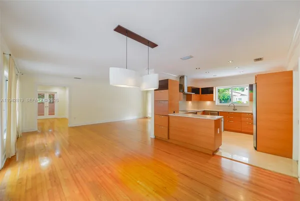 a kitchen with stainless steel appliances a refrigerator and wooden floor