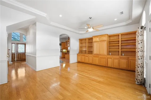a view of an empty room with window and wooden floor