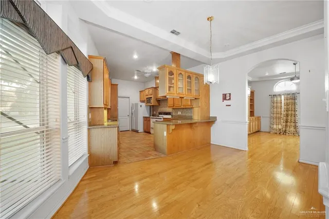 a view of a kitchen with kitchen island stainless steel appliances refrigerator sink and cabinets