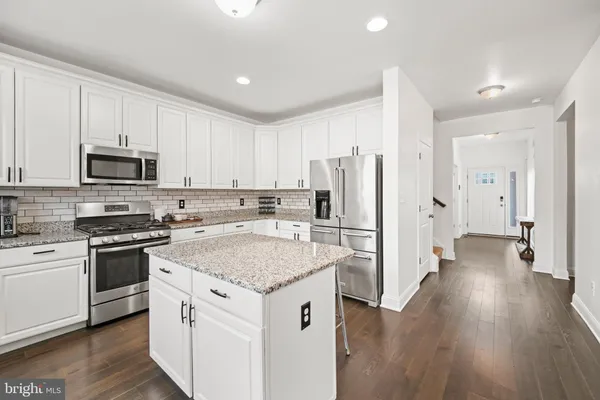 a kitchen with stainless steel appliances a refrigerator stove and wooden cabinets